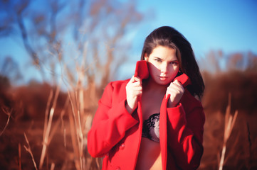 Brunette woman in red coat with underwear outdoor