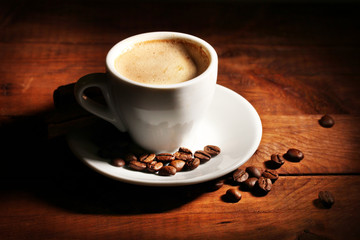cup with coffee and coffee beans on  wooden table