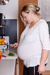 Hochschwangere Frau beim Kochen