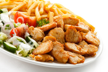 Grilled meat with French fries and vegetables