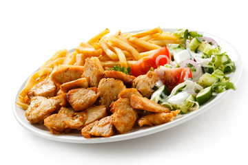 Grilled meat with French fries and vegetables