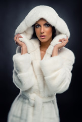 Beautiful woman in white fashionable fur coat