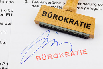 Holzstempel auf Dokument: Bürokratie