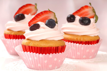Vanilla cupcakes with stawberry frosting and strawberries and bl