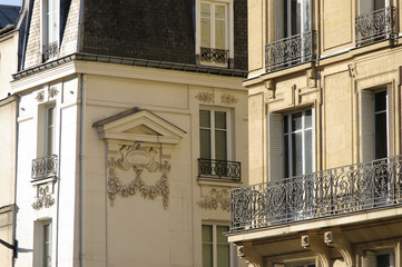 Façade de pierre blanche avec balcon de fer.
