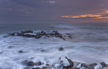 Waves on rocky beach before sunrise