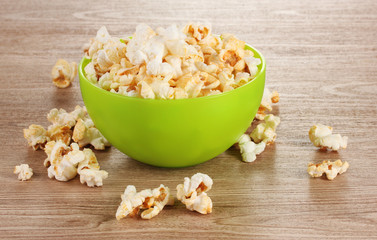 popcorn in bright plastic bowl on wooden table