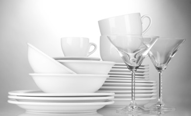 empty bowls, plates, cups and glasses on grey background
