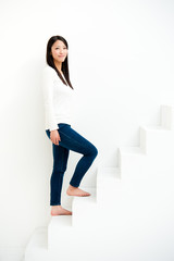 attractive asian woman on stairs in the white room