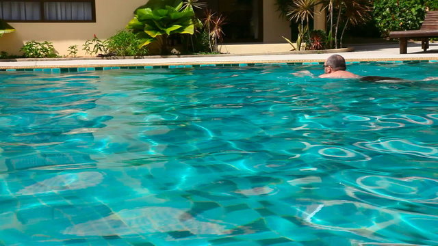 A man swims in the hotel pool.