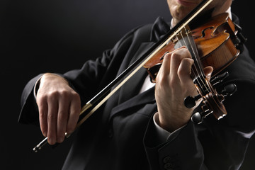 the violinist: Musician playing violin on dark background