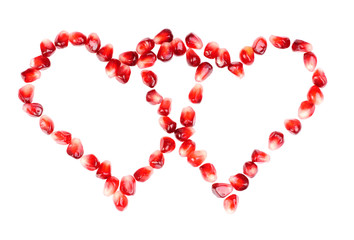 pomegranate seeds as heart shaped  isolated  on  white
