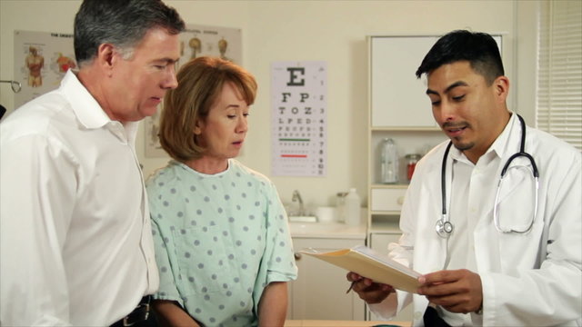 Hispanic Doctor Talks to Couple