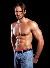 handsome powerful muscular man isolated on black