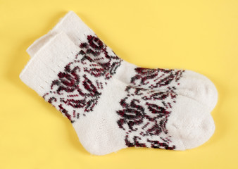 Knitted wool socks on a yellow background