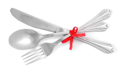Silver fork and spoon, knife tied with a red ribbon isolated