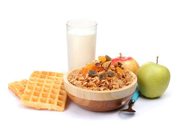 tasty cornflakes in wooden bowl, apples and glass of milk