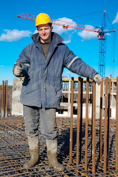 Smiling builder worker at construction site showing a thumb up