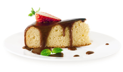 A piece of sponge cake with chocolate sauce on a white plate.