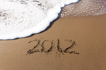 2012 written in sand with waves