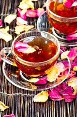 Tea with roses petals on bamboo surface