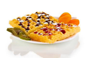 Sweet waffles with jam and chocolate on plate isolated on white
