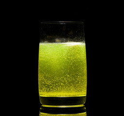 aspirin tablet in glass of water over black