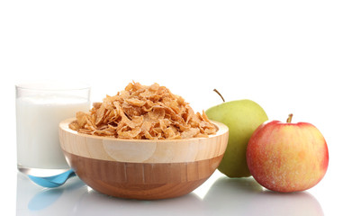 tasty cornflakes in wooden bowl, apples and glass of milk