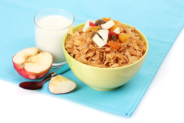 tasty cornflakes in bowl with dried fruits, glass of milk and
