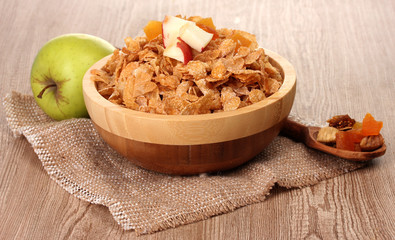 tasty cornflakes in bowl with dried fruits, glass of milk and