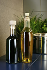 Oil and vingar bottles in front of herbs