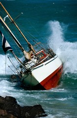 Naklejka premium yacht crash on the rocks in stormy weather