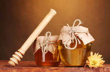 two jars of honey and wooden drizzler