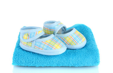 Blue baby booties on blue towel isolated on white