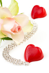 rose, bonbon hart and diamond necklace over white background