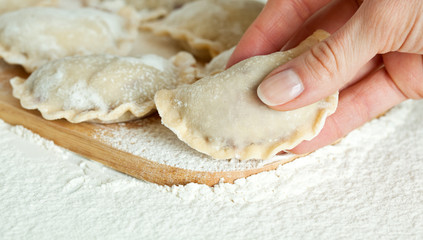 Dumplings in flour on the wooden board