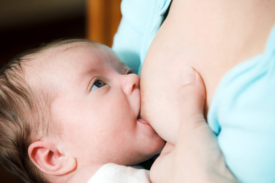 Mother breast feeding newborn baby