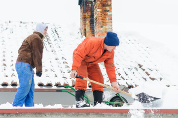 Men cleaning snow on roof