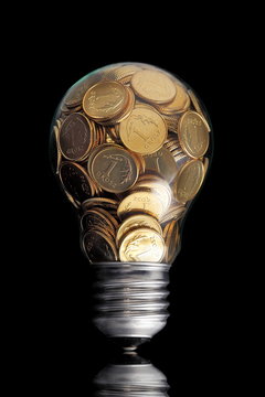 Traditional glass bulb with many golden coins on black