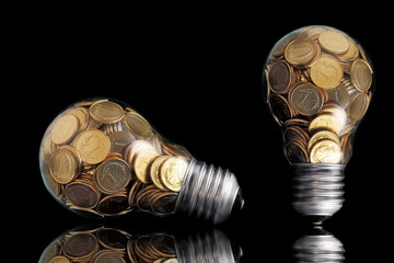 Traditional glass bulb with many golden coins on black
