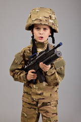 Young boy dressed like a soldier with rifle