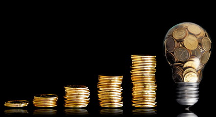 Traditional glass bulb with many golden coins on black