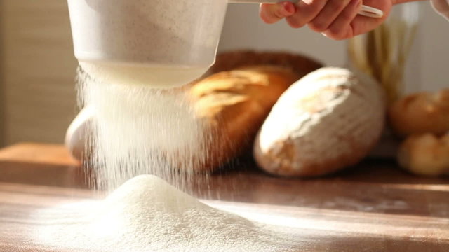 Hand sifts the flour through a sieve, slow motion