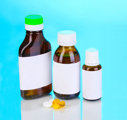 Medical bottles and tablets on blue background