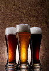 Three cold Beer into glass on a old stone