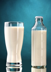 bottle and glass of milk on blue background