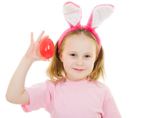 Obraz na płótnie Canvas The little girl with pink ears bunny with an egg