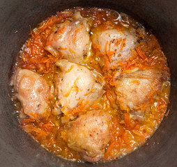 Chicken meat is fried in a copper with spices