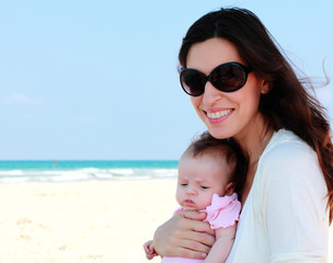 mother with her baby on the beach