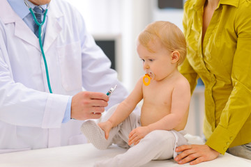 Obraz na płótnie Canvas Baby being checked by pediatrician doctor using stethoscope